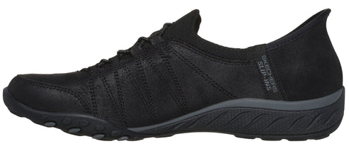 A black slip-on shoe with a low profile and a textured sole.