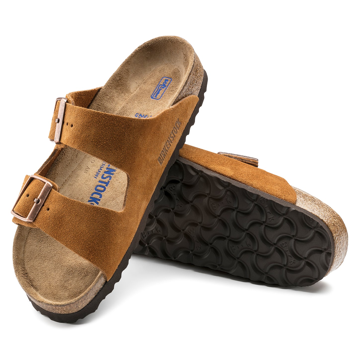 Two brown suede sandals, one upright, one on its side showing the sole.