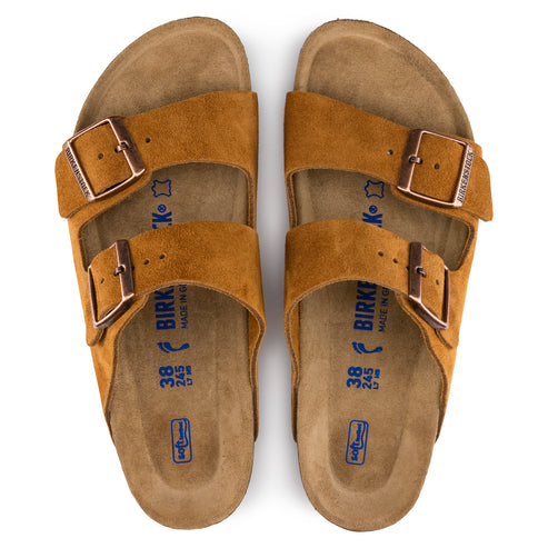 A pair of brown suede sandals with adjustable straps and metal buckles, showing the footbed with visible size markings.