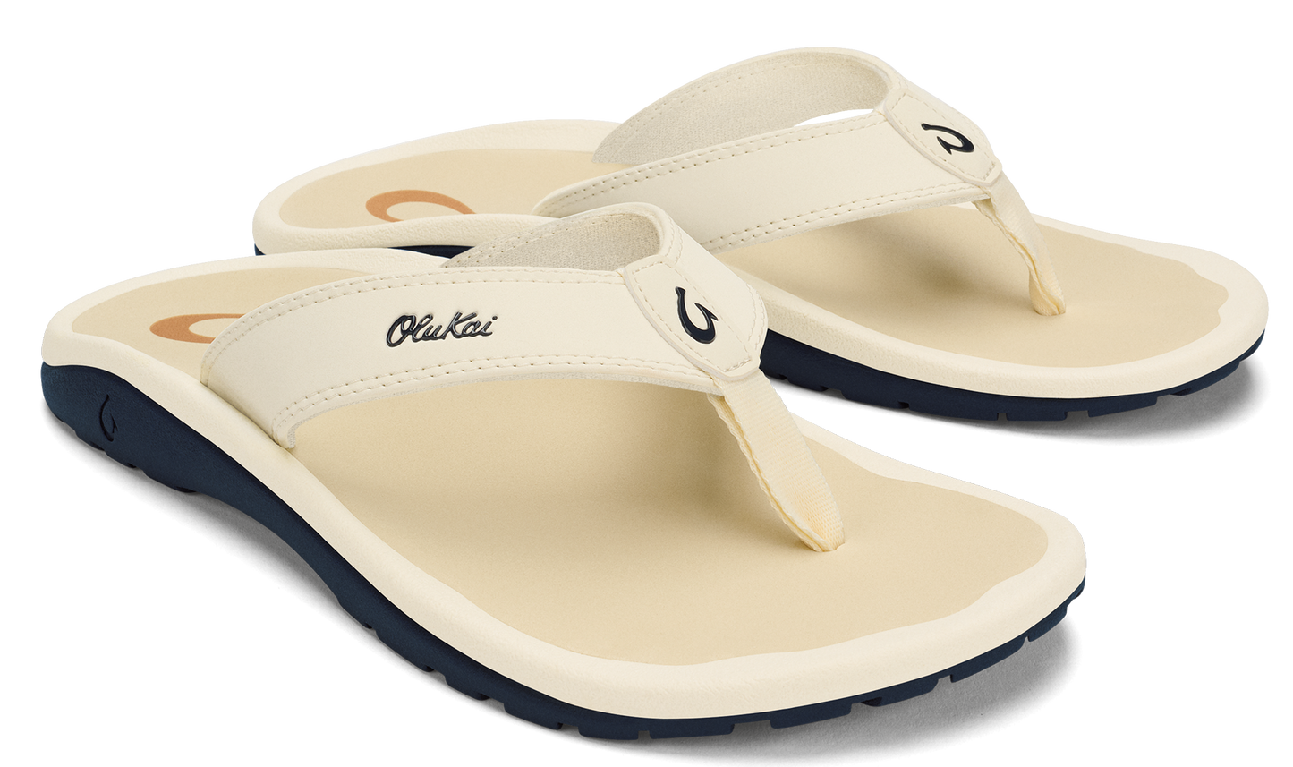 Pair of off-white flip-flops with black soles and OluKai logo.