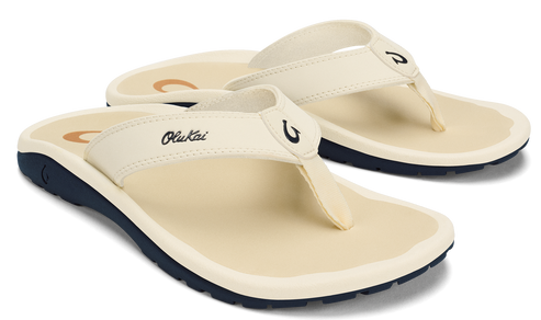 Pair of off-white flip-flops with black soles and OluKai logo.