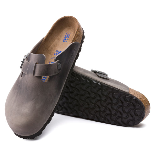 Pair of gray clog shoes with adjustable strap and rubber sole.