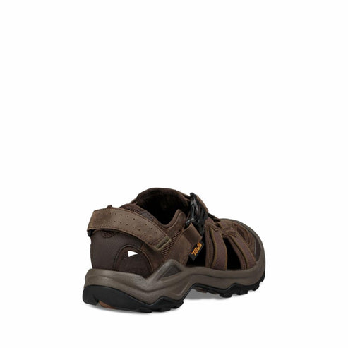 Brown sandal with cutouts, textured sole, and adjustable ankle strap as viewed from the back.