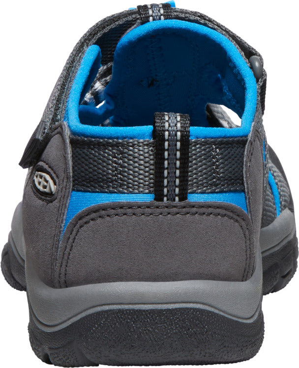 A sandal with a grey heel, grey straps, and blue interior lining.