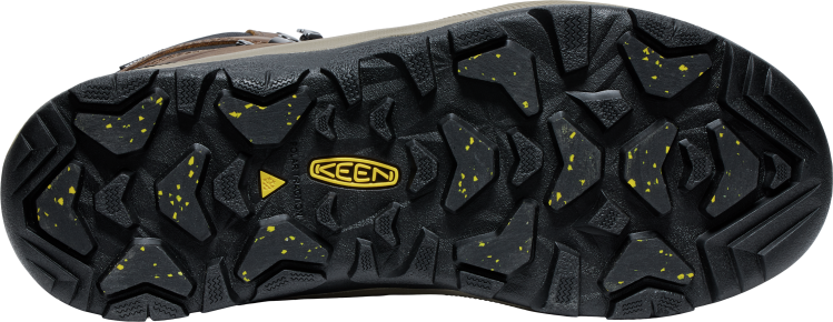 A shoe's outsole with aggressive lug patterns and embedded yellow particles.  A yellow KEEN logo is in the center.