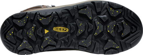 A shoe's outsole with aggressive lug patterns and embedded yellow particles.  A yellow KEEN logo is in the center.