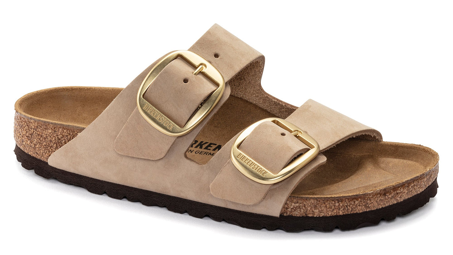 Beige slide sandal with two wide adjustable straps and oversized gold buckles.