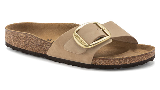 Beige slide sandal with an oversized brass buckle.
