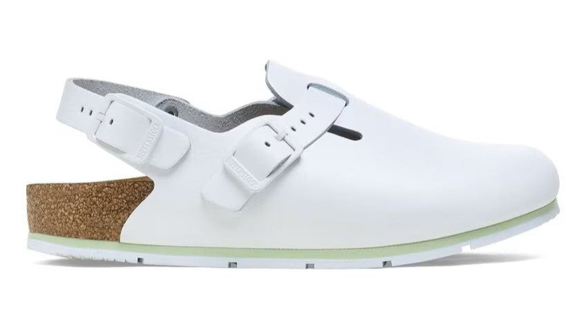 White clog-style shoe with an adjustable buckle strap and cork sole.
