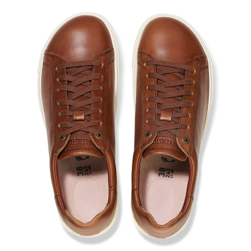 Top-down view of brown leather lace-up sneakers.