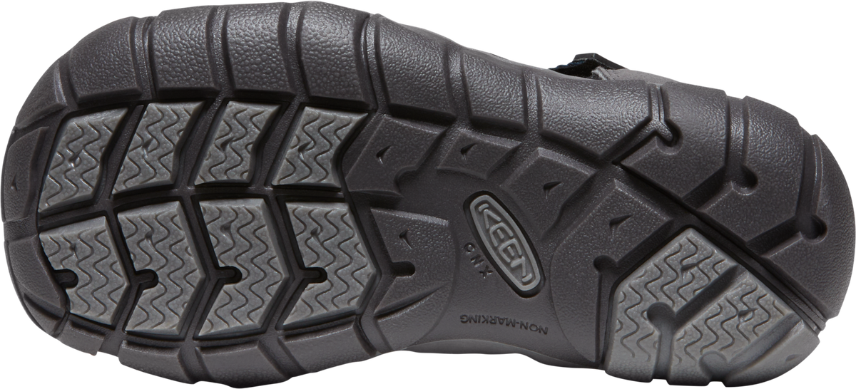 Bottom view of a black shoe with a thick, lugged sole featuring zig-zag patterns and a KEEN logo.