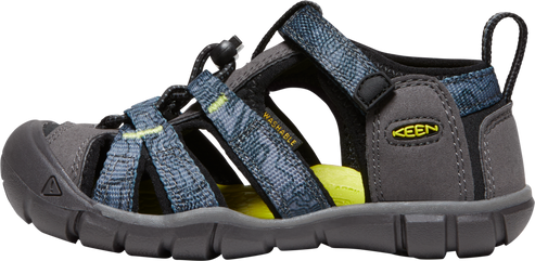 A close-up shot of a KEEN brand sandal with gray toe, soles and trim, as well as blue and gray patterned straps.