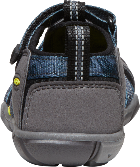 Back view of a shoe with blue textile material, gray suede accents, and a black hook-and-loop fastener strap.