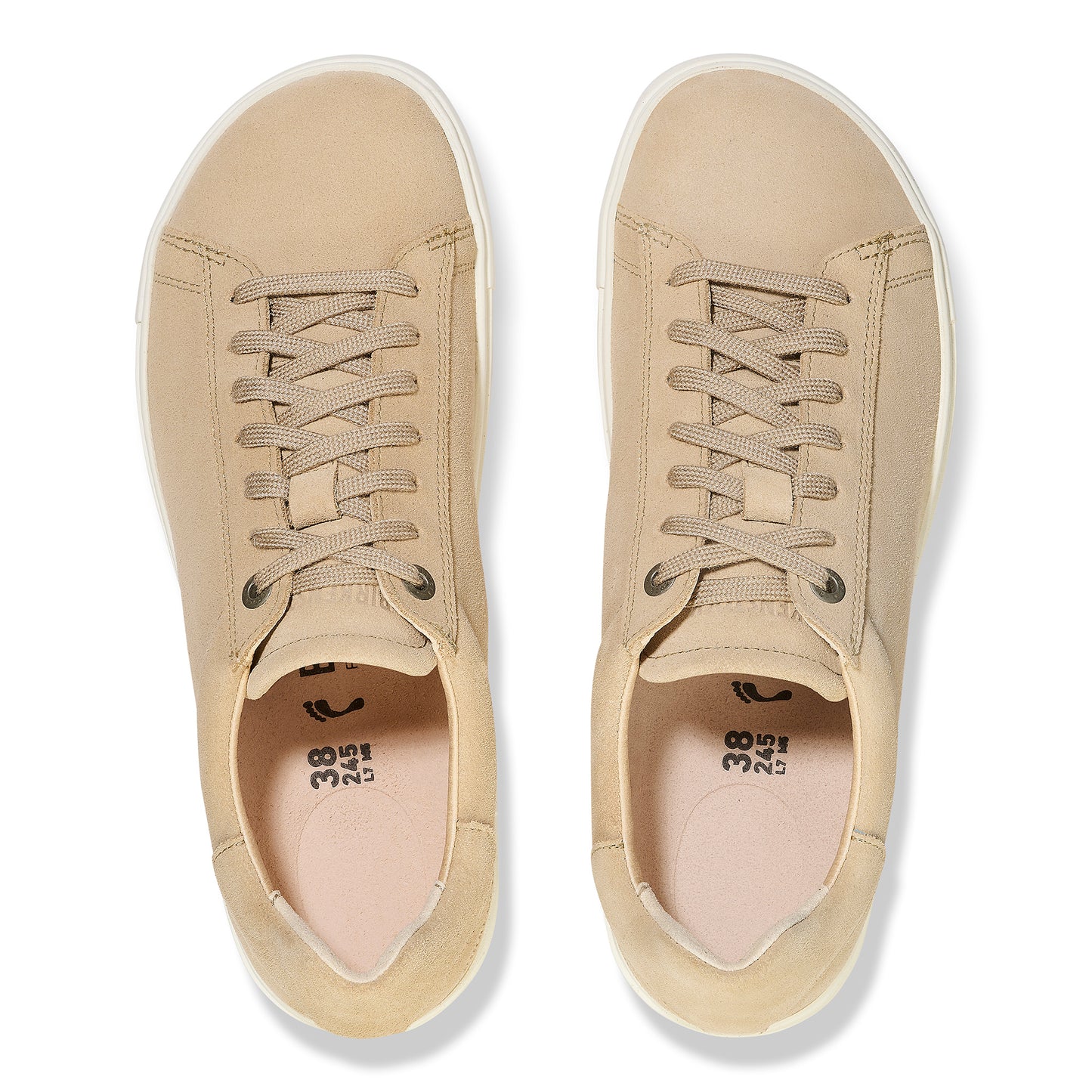 Top-down view of two tan leather sneakers with white soles and tan laces.