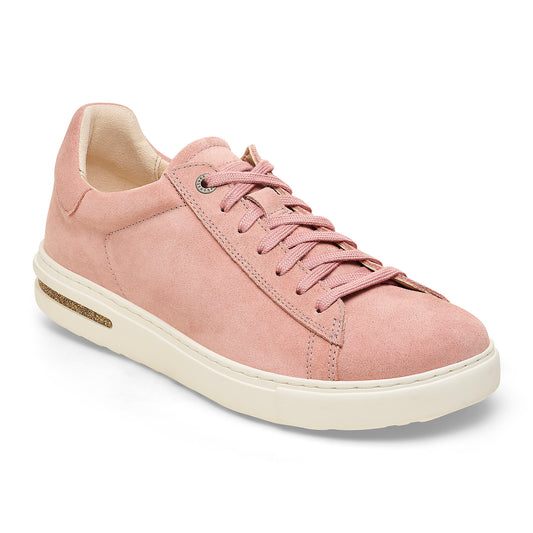 Low-top pink suede sneaker with white sole.