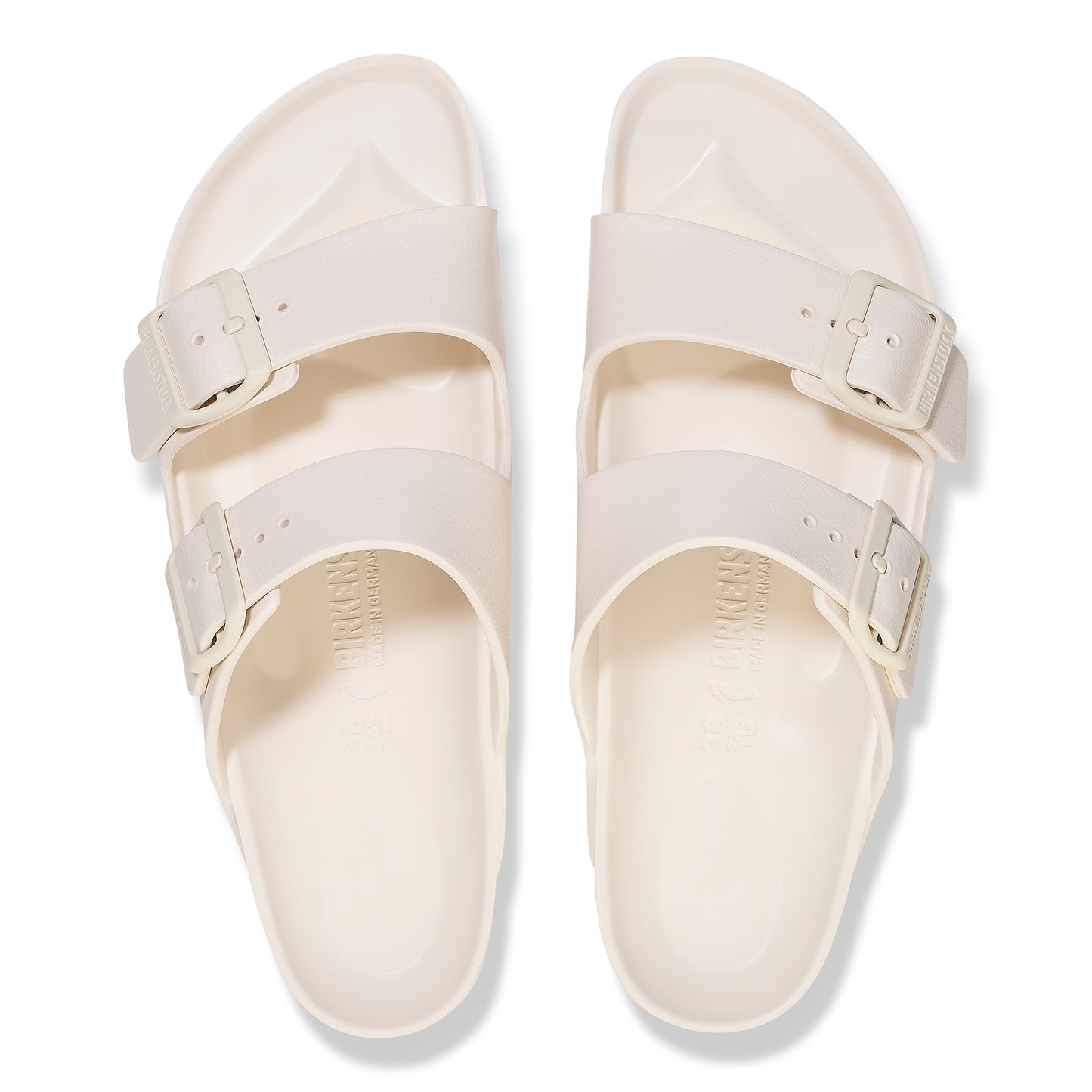 Two white, rubber sandals with two adjustable buckle straps each, seen from above.