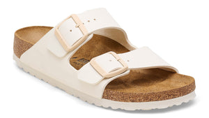 White two-strap sandal with adjustable buckles and a cork footbed.