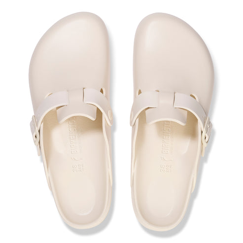 Pair of white clogs with adjustable straps.