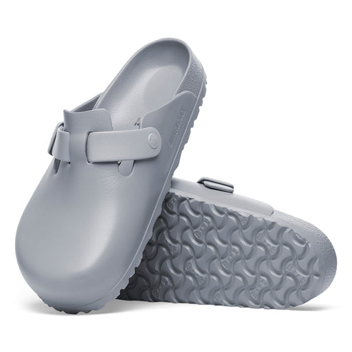 Pair of gray slip-on clogs with adjustable side straps and textured soles.