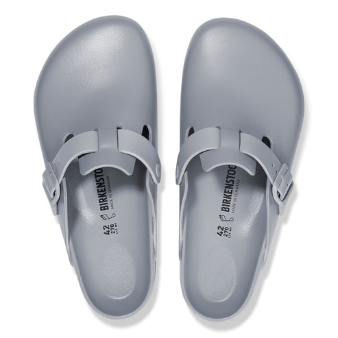 Two light gray clogs with adjustable buckle straps.
