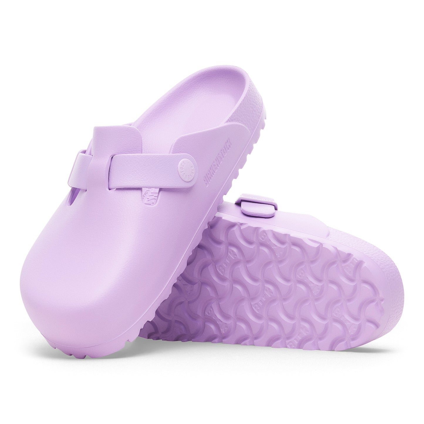 Two light-purple clog shoes, one leaning on the other, showing the textured sole.