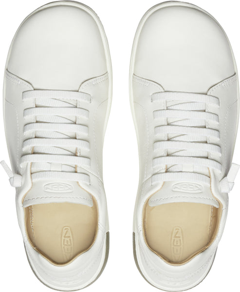 Overhead view of two white lace-up sneakers; leather upper, round toe, and a beige insole.