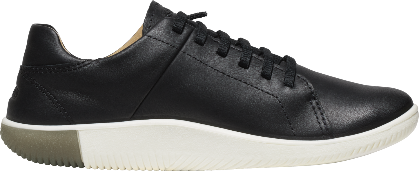 A black leather sneaker with white soles and black laces.