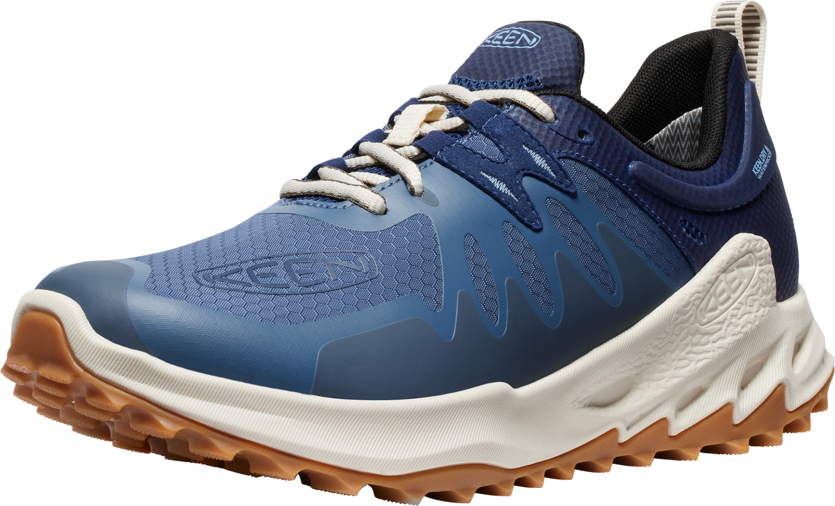 Low profile trail running shoe in blue with white laces and sole and brown lugs.
