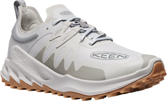 A white running shoe with brown lug sole and gray accents. The side displays the brand KEEN.