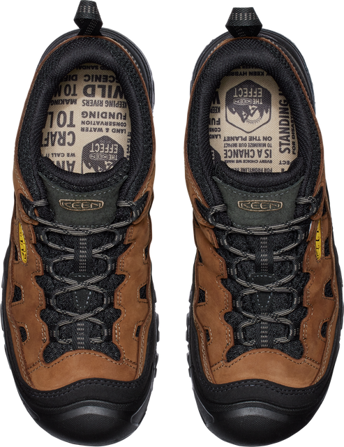 An overhead view of brown and black hiking shoes with black laces and black soles.