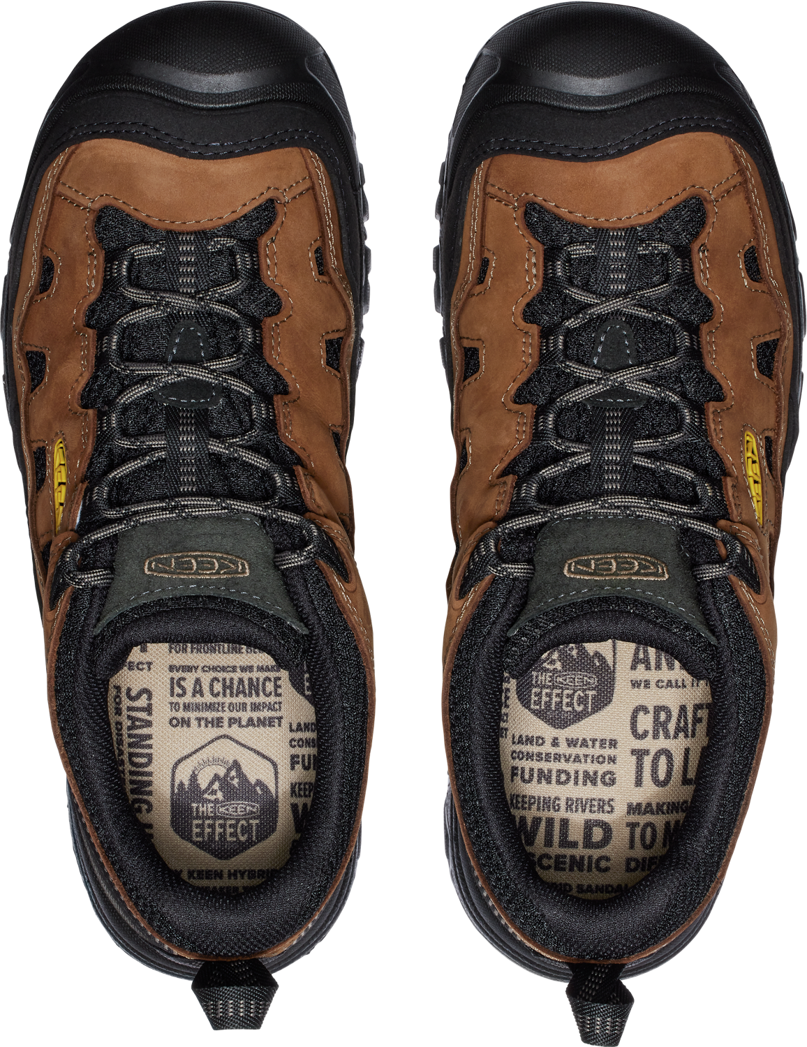 A top-down view of two brown hiking boots. The tongues have black laces and the insole is patterned with text: "Every choice we make is a chance to minimize our impact on the planet. The Scenic Effect, land & water, conservation funding, keeping rivers wild to making scenic dinner."