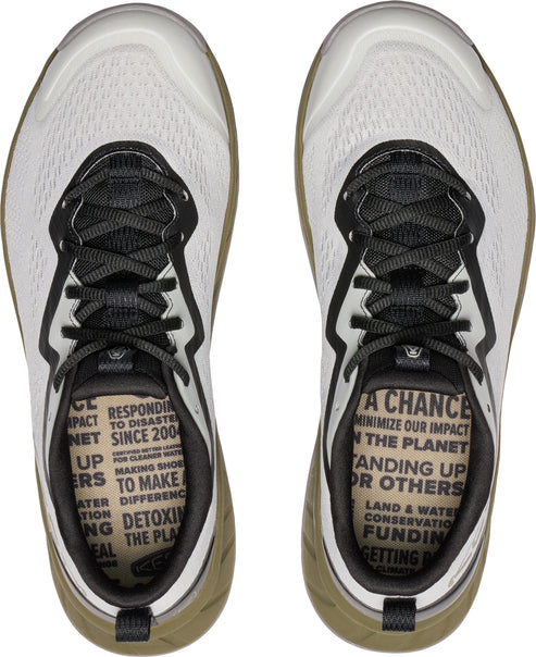 Top-down view of a pair of white sneakers with black laces, showcasing a textured insole with text.