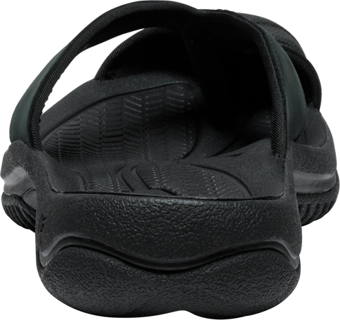 Close-up of a black sandal with a textured footbed and thick sole.