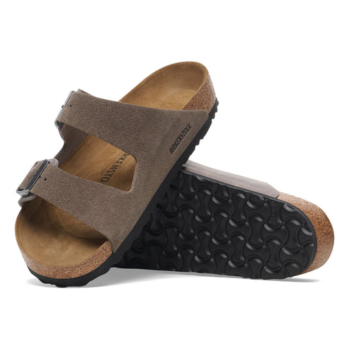 Two suede sandals with adjustable straps and black soles.
