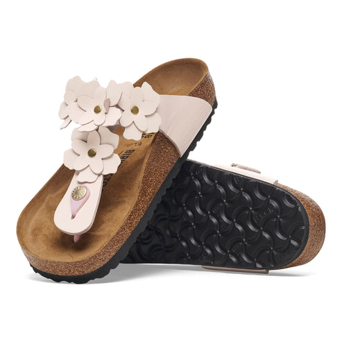 A pair of thong sandals with decorative leather flowers and a cork sole.