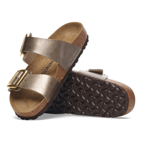 A pair of bronze-colored sandals with two straps and gold buckles, showcasing the side and sole.