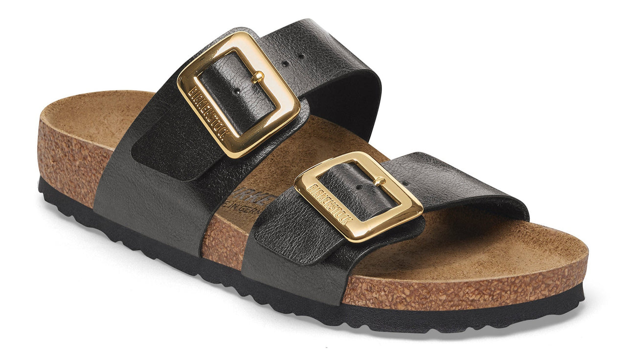 Black sandal with two straps and gold buckles.