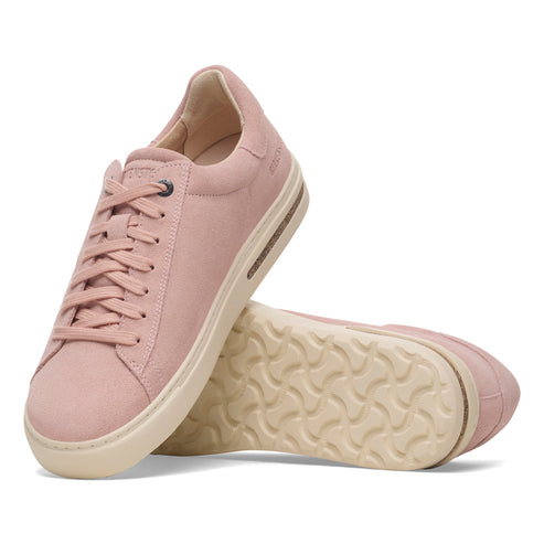 Pair of low-rise pink sneakers with a white sole and lace-up closure.