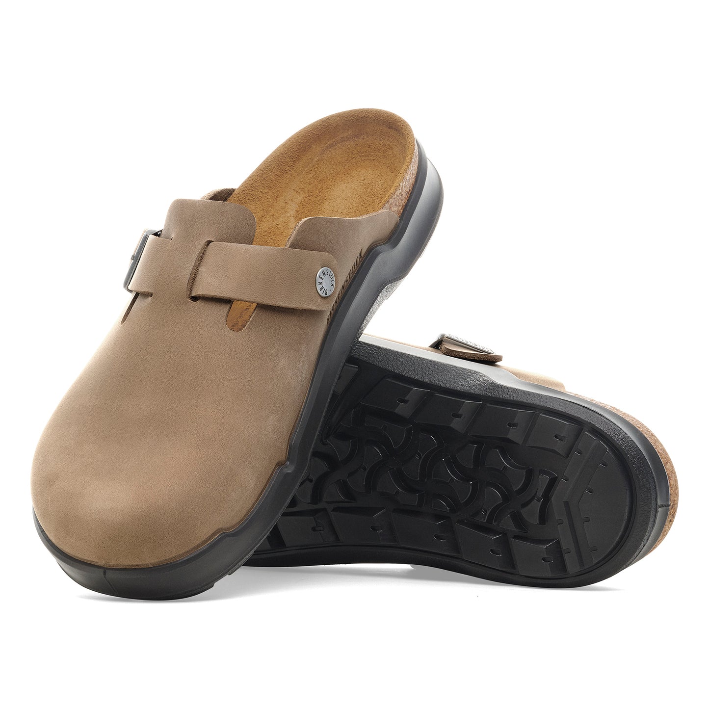 Pair of light brown clog-style shoes with black soles, one shoe laying on its side to display tread pattern, adjustable strap.