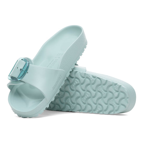 Two mint green slide sandals with a translucent buckle lying on their sides.