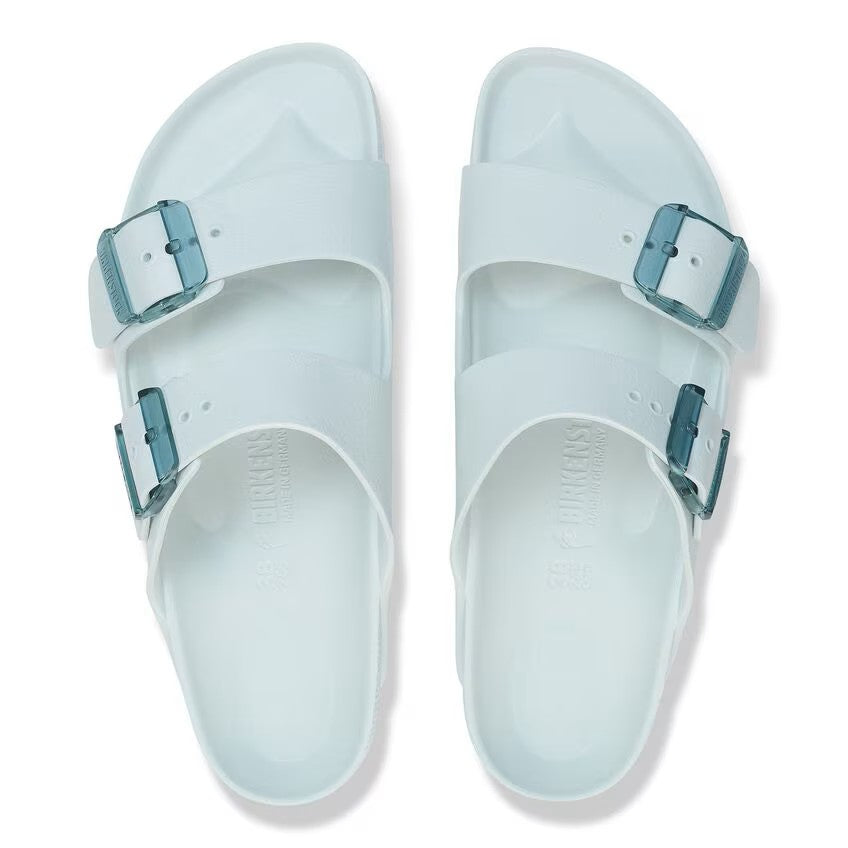 Two clear sandals with two straps each and blue buckles.