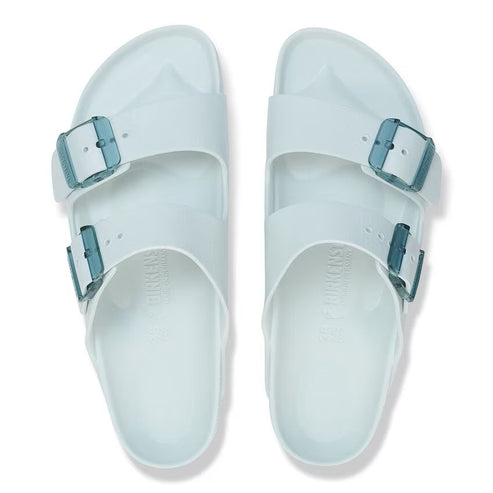Two clear sandals with two straps each and blue buckles.
