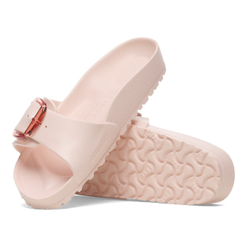 Pair of pink slides with an adjustable rose gold buckle, showing textured soles.
