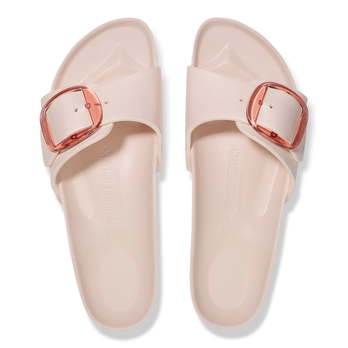 Pair of light pink slide sandals with square, rose-gold buckles.