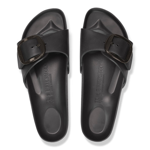 Overhead view of two black, molded plastic sandals with large buckles.