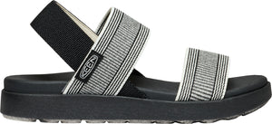 A sandal with a thick black sole, black back strap, and striped gray and white elastic bands.