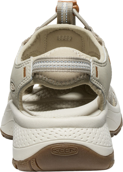 Tan-colored sandal with open toe and heel, adjustable bungee cord, and textured sole with logo.