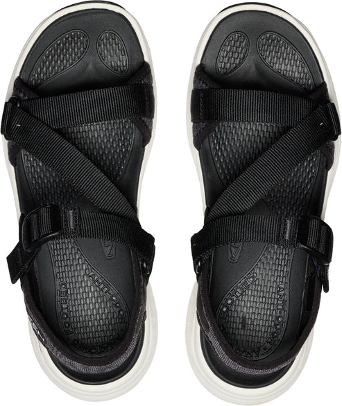 Top-down view of black sandals with white soles, featuring a criss-cross strap design and buckle closures.