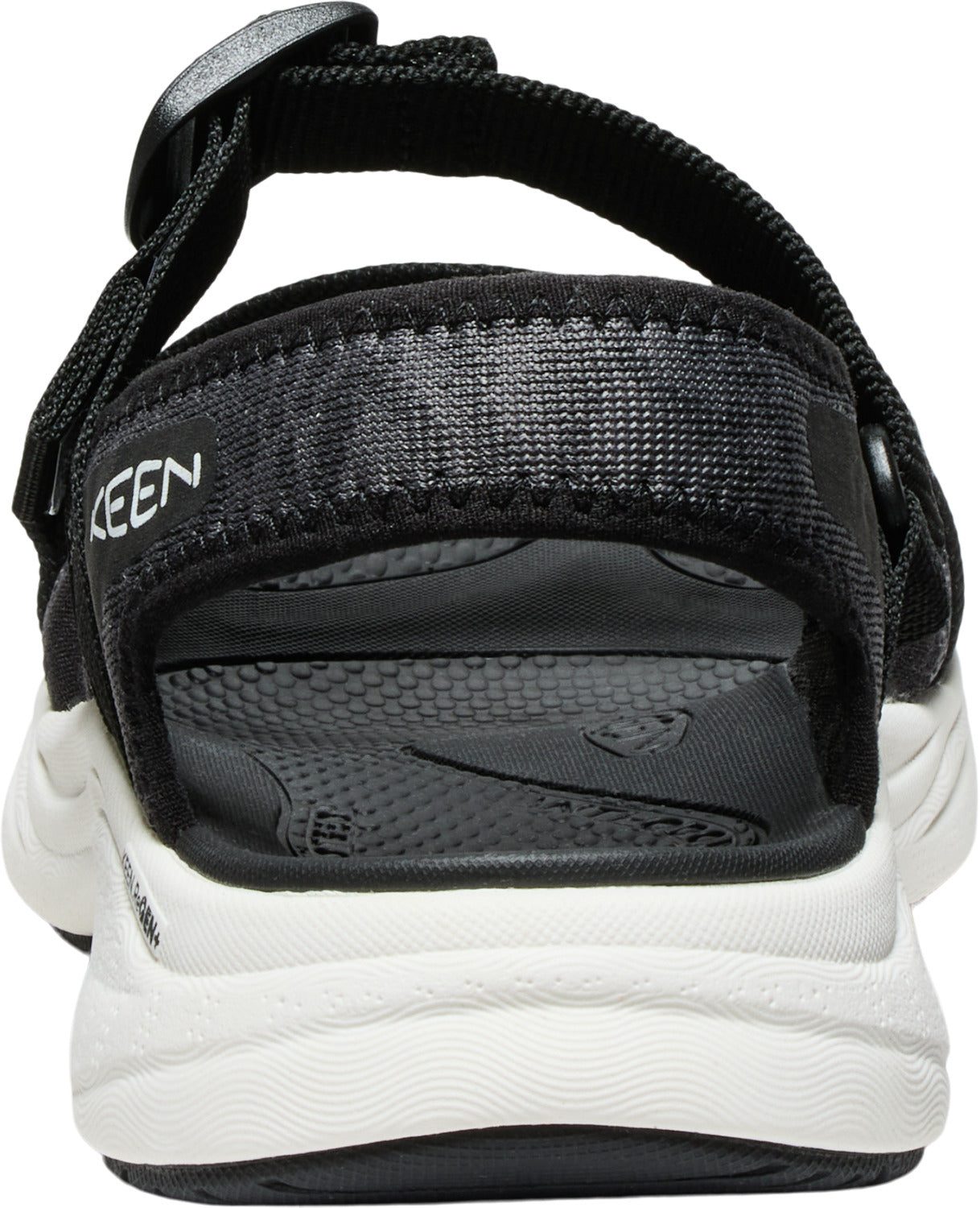 Back view of a black sandal with white sole, KEEN lettering visible on upper strap.