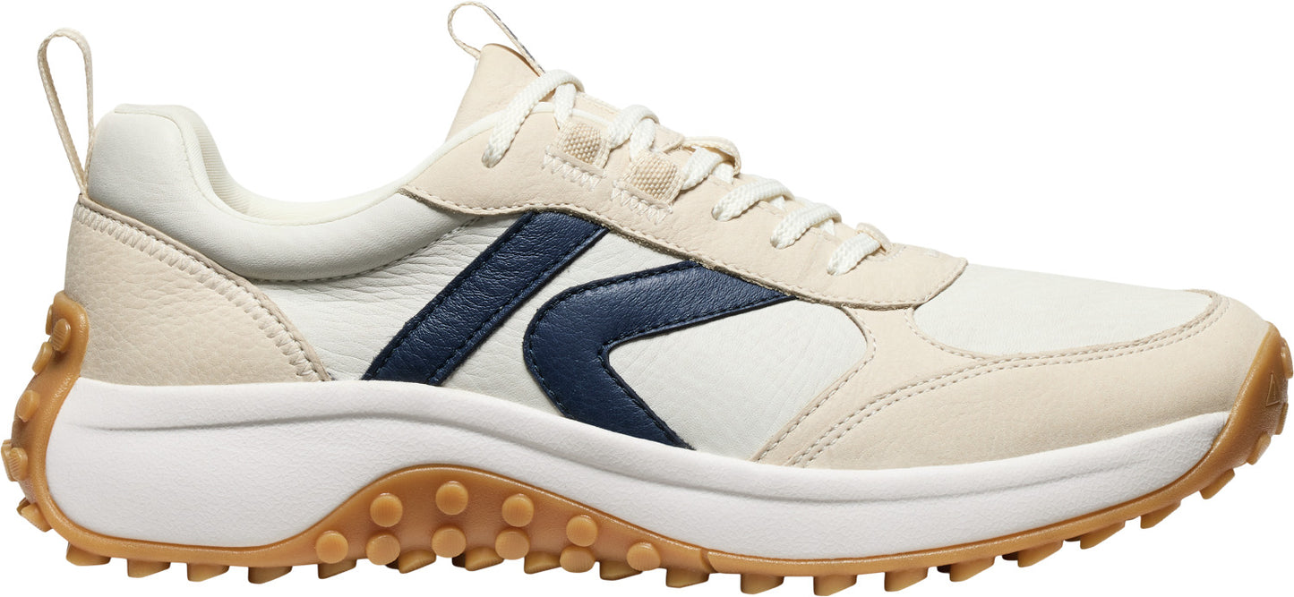 A low-top sneaker with off-white and blue leather paneling and a brown treaded sole.